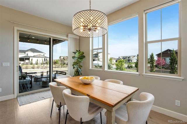 dining area featuring an inviting chandelier, wood finished floors, and baseboards