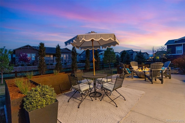 patio terrace at dusk with an outdoor fire pit and fence