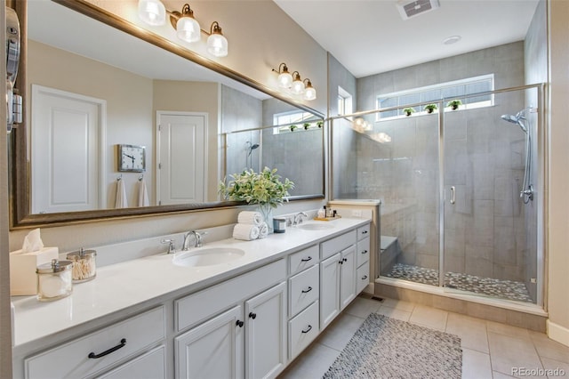 full bath featuring a shower stall, visible vents, a sink, and double vanity