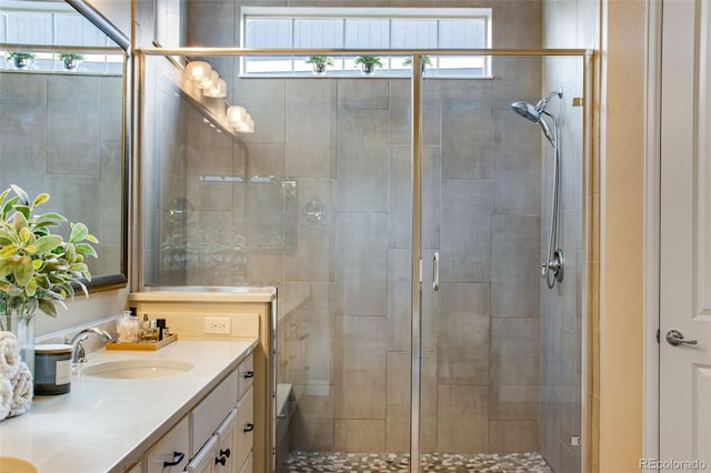 full bath featuring a shower stall, double vanity, and a sink
