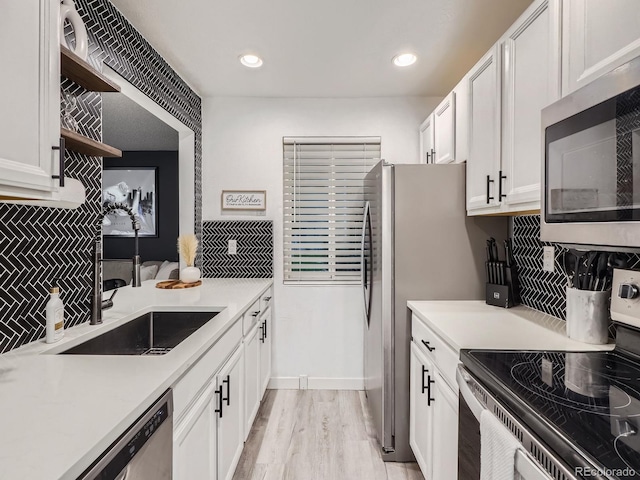 4068 S Atchison Way Unit 101, Aurora, CO 80014 - kitchen featuring appliances with stainless steel finishes, white cabinetry, decorative backsplash, open shelves, and light countertops