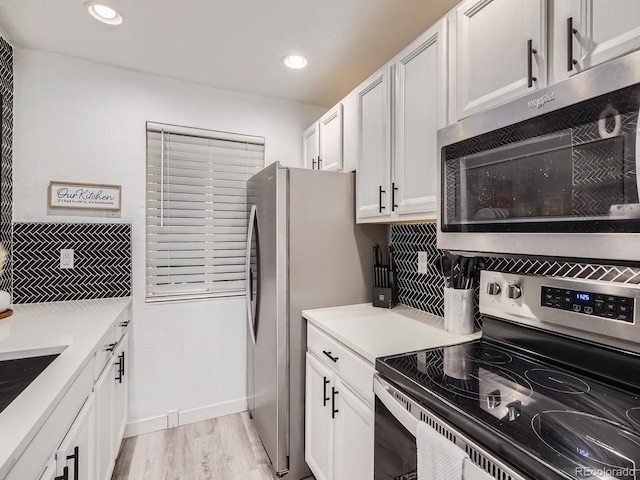 4068 S Atchison Way Unit 101, Aurora, CO 80014 - kitchen with stainless steel appliances, decorative backsplash, white cabinets, light countertops, and light wood finished floors