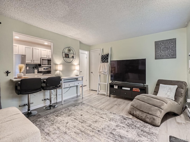 4068 S Atchison Way Unit 101, Aurora, CO 80014 - living room with light wood-style flooring and a textured ceiling