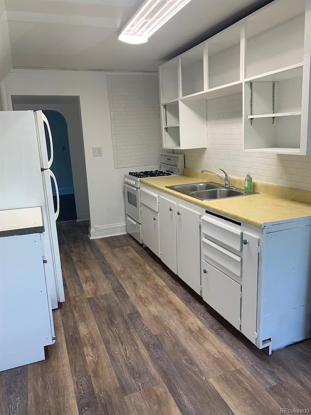 kitchen with a sink, white appliances, open shelves, and light countertops