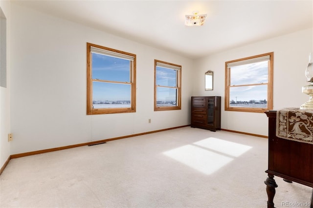 unfurnished bedroom with light colored carpet, visible vents, and baseboards