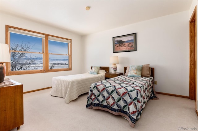 bedroom featuring light carpet and baseboards