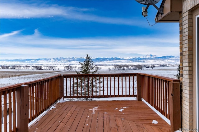 snow covered deck with a mountain view