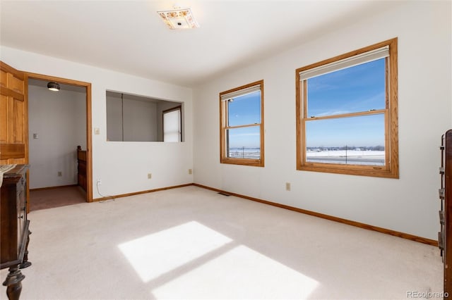 interior space featuring light colored carpet, visible vents, and baseboards