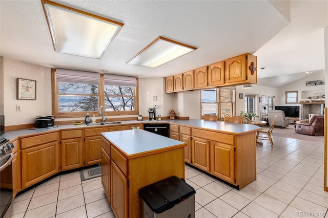 kitchen with a center island, light tile patterned floors, light countertops, open floor plan, and a sink