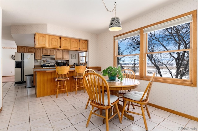 dining room featuring light tile patterned flooring, baseboards, and wallpapered walls
