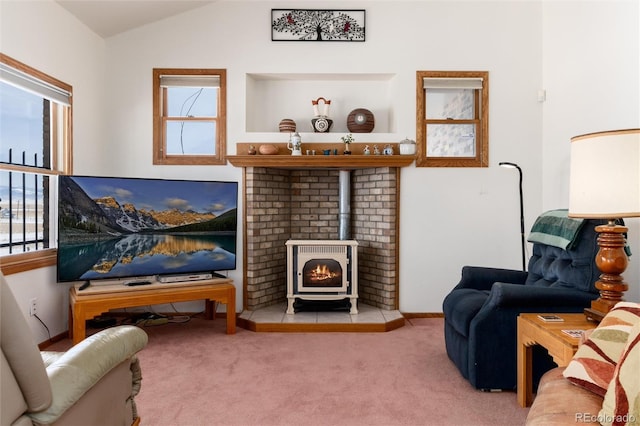 sitting room featuring lofted ceiling, a wood stove, light colored carpet, and baseboards