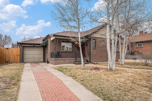 bungalow-style home with a garage, concrete driveway, brick siding, and fence