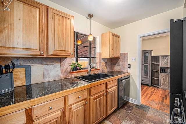 kitchen featuring tasteful backsplash, dishwasher, tile countertops, stone finish floor, and a sink