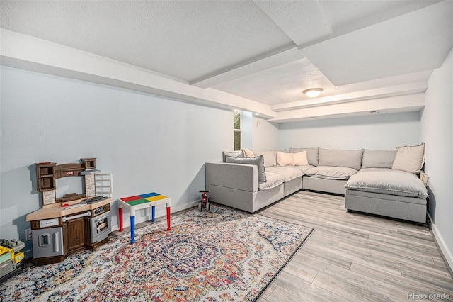 living area with a textured ceiling, wood finished floors, and baseboards