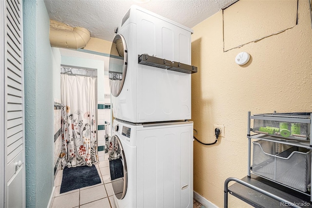 clothes washing area featuring laundry area, a textured ceiling, stacked washer / drying machine, and a textured wall