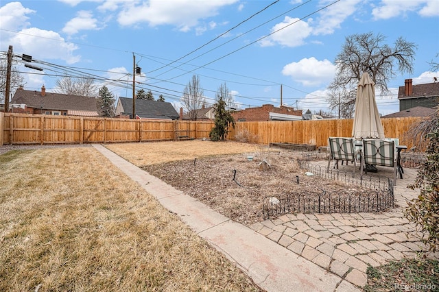 view of yard featuring a patio, outdoor dining area, and a fenced backyard