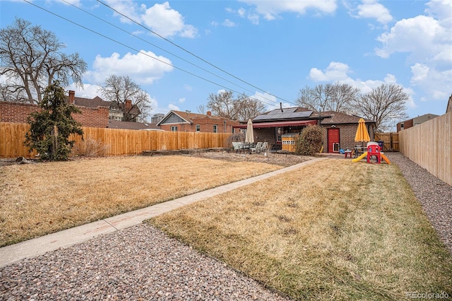 view of yard with a fenced backyard and a playground