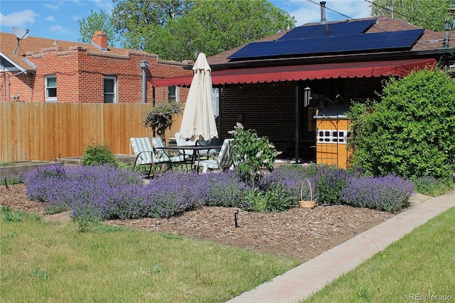 1363 Stuart St, Denver, CO 80204 - back of property featuring fence, solar panels, brick siding, a patio area, and a chimney