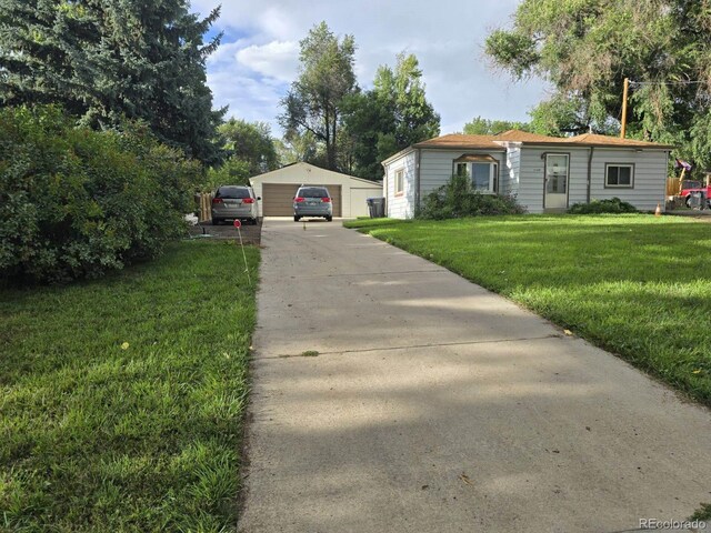 view of front of home with a front yard, a garage, and an outdoor structure