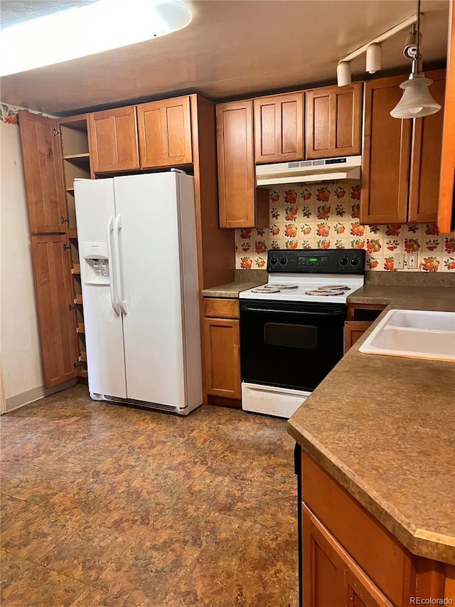 kitchen featuring decorative light fixtures, white refrigerator with ice dispenser, and range with electric cooktop