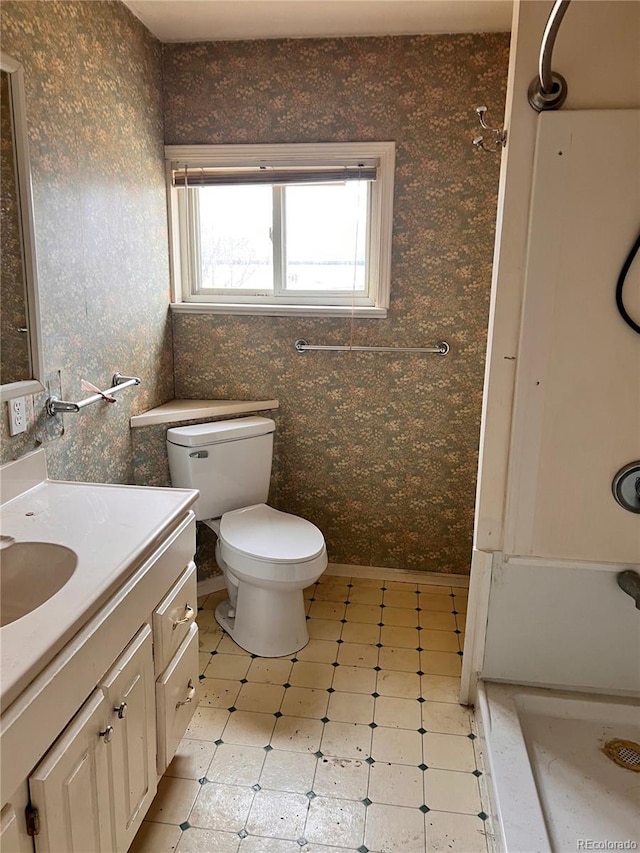 bathroom featuring vanity, a shower, and toilet