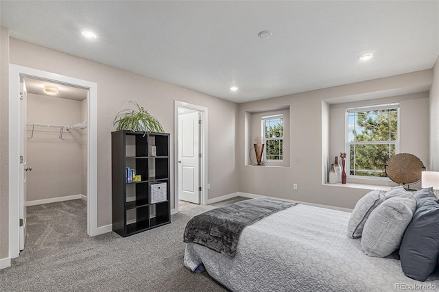 carpeted bedroom featuring a closet and a walk in closet