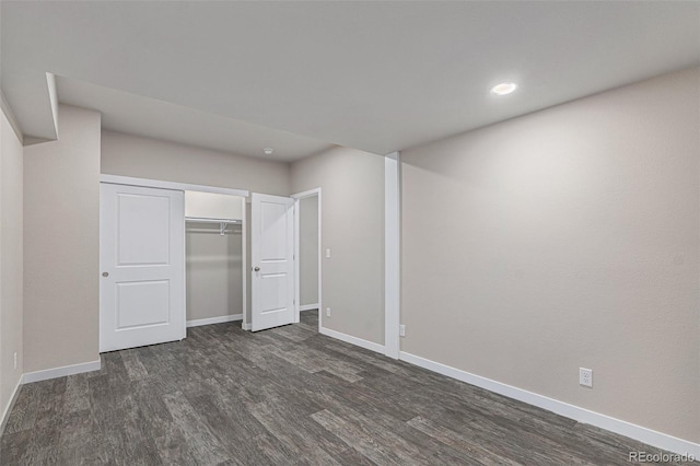 unfurnished bedroom featuring dark hardwood / wood-style flooring and a closet