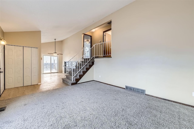 carpeted spare room with high vaulted ceiling