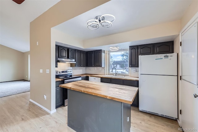 kitchen with butcher block counters, sink, a center island, white appliances, and light hardwood / wood-style flooring