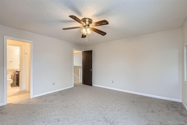 carpeted empty room with ceiling fan and a textured ceiling