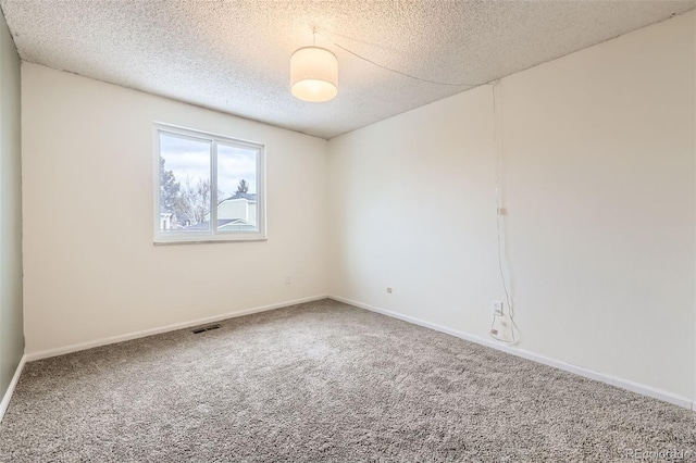 carpeted empty room with a textured ceiling