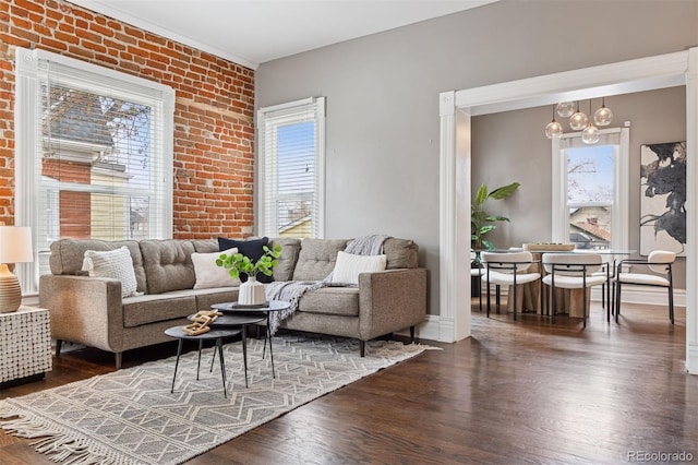 321 S Emerson St, Denver, CO 80209 - living room featuring healthy amount of natural light, a chandelier, brick wall, and wood finished floors
