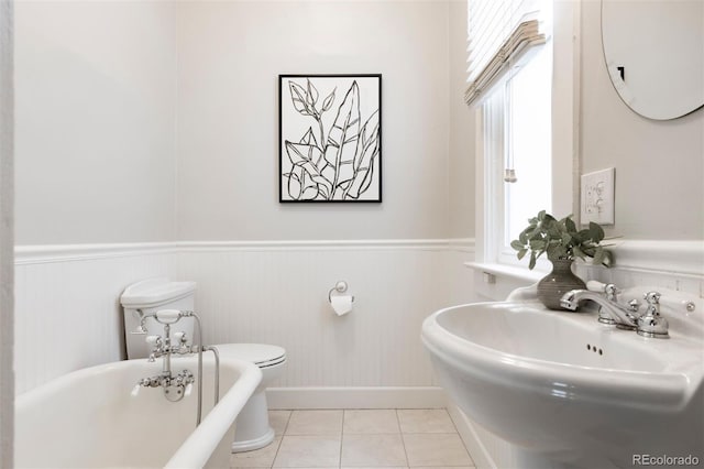 321 S Emerson St, Denver, CO 80209 - bathroom featuring a soaking tub, a wainscoted wall, a sink, tile patterned floors, and baseboards