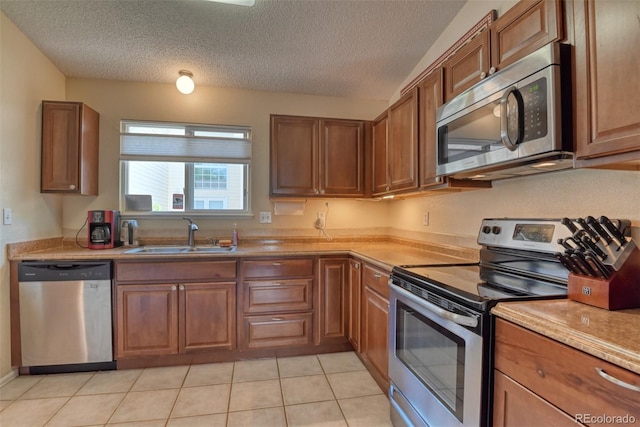 972 Columbine Ave, Colorado Springs, CO 80904 - kitchen with appliances with stainless steel finishes, a textured ceiling, light countertops, and brown cabinetry