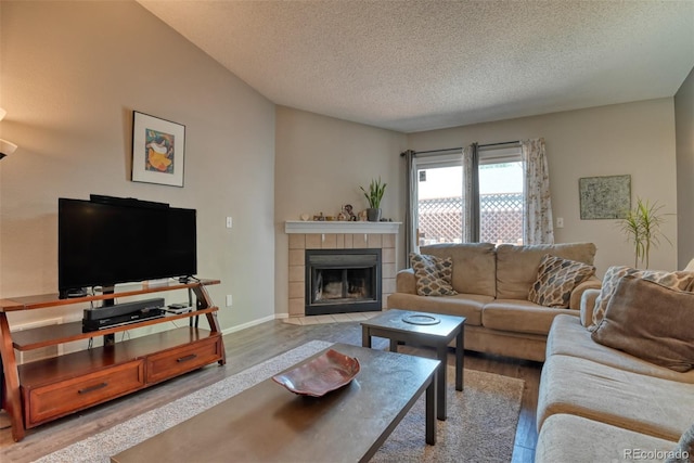 972 Columbine Ave, Colorado Springs, CO 80904 - living area featuring a tile fireplace, a textured ceiling, and light wood finished floors