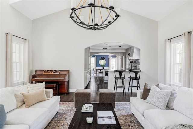 8739 E 23rd Ave, Denver, CO 80238 - living room with arched walkways, a chandelier, dark wood-style flooring, plenty of natural light, and a towering ceiling