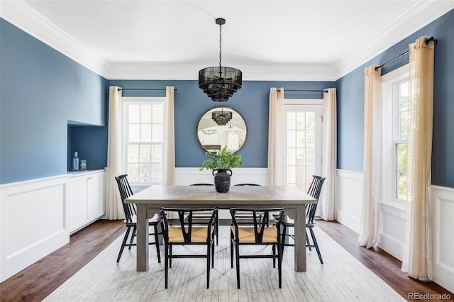 8739 E 23rd Ave, Denver, CO 80238 - dining room with a chandelier, a wainscoted wall, wood finished floors, crown molding, and a decorative wall