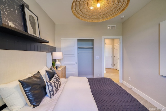 carpeted bedroom with baseboards and a closet