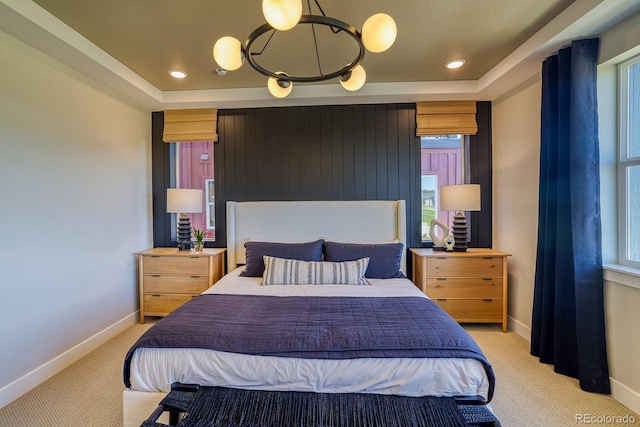 bedroom featuring light colored carpet, baseboards, a raised ceiling, and recessed lighting