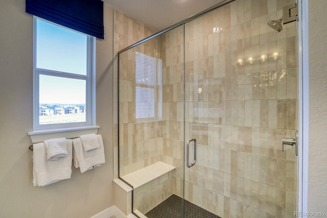 bathroom featuring a stall shower and baseboards