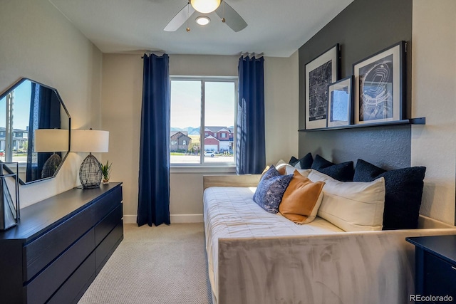 bedroom featuring light carpet, baseboards, and a ceiling fan