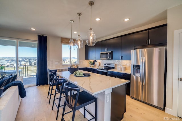 kitchen featuring stainless steel appliances, a kitchen breakfast bar, a center island, recessed lighting, and tasteful backsplash