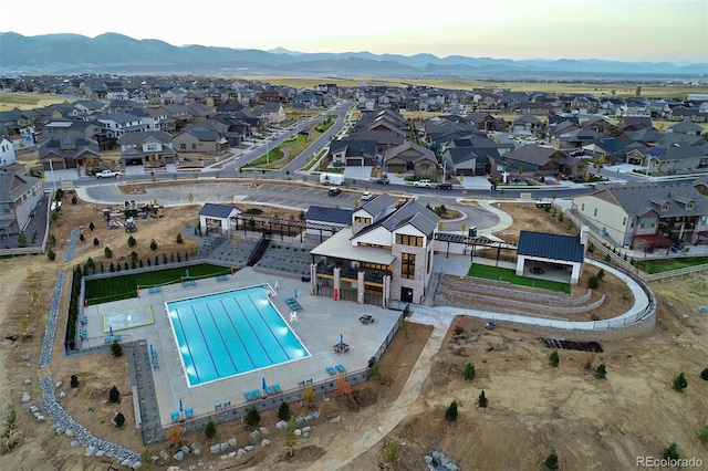 aerial perspective of suburban area with a pool and a mountainous background