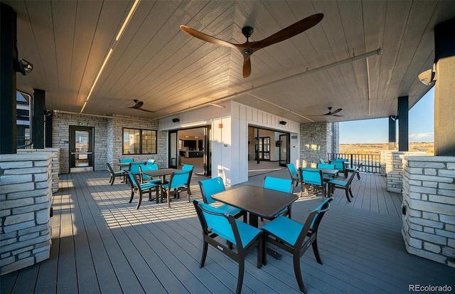 deck with outdoor dining space and a ceiling fan