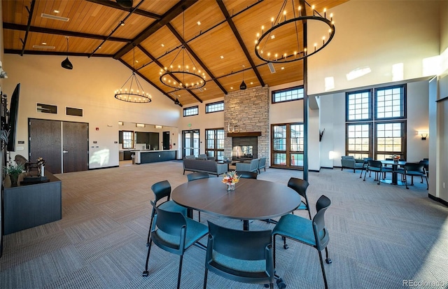 carpeted dining area featuring high vaulted ceiling, wooden ceiling, a chandelier, plenty of natural light, and beam ceiling