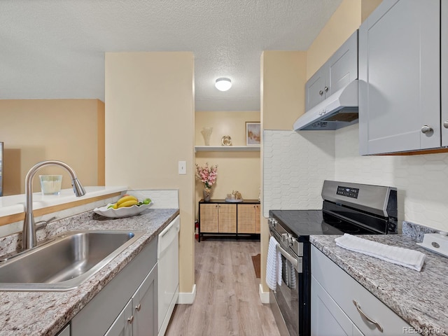 kitchen with dishwasher, light wood-type flooring, a textured ceiling, sink, and stainless steel range with electric cooktop