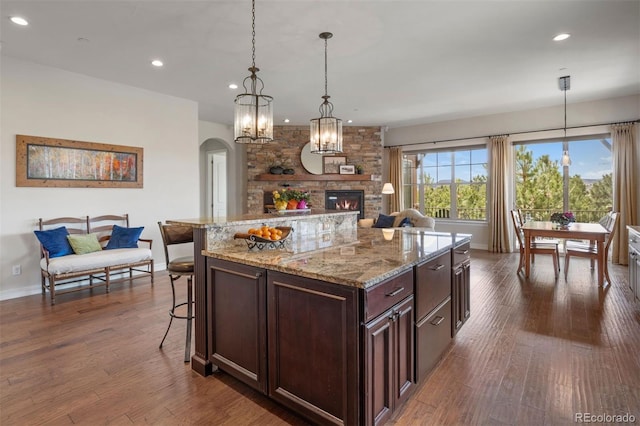 kitchen featuring recessed lighting, baseboards, arched walkways, and open floor plan