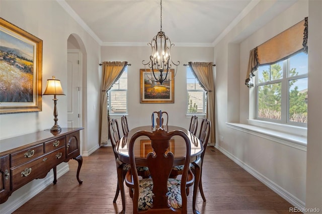 dining area featuring dark wood-type flooring, arched walkways, baseboards, and a notable chandelier
