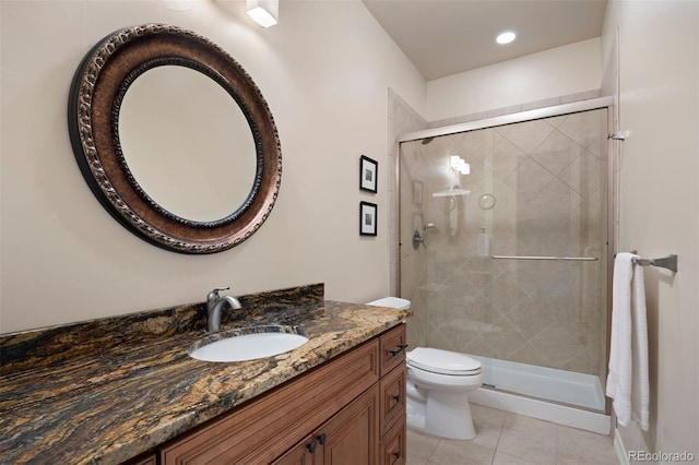 bathroom with vanity, tile patterned floors, a shower stall, and toilet
