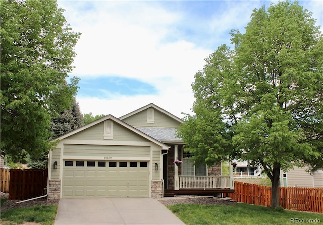 16179 W 70th Pl, Arvada, CO 80007 - view of front of home featuring stone siding, fence, an attached garage, and concrete driveway